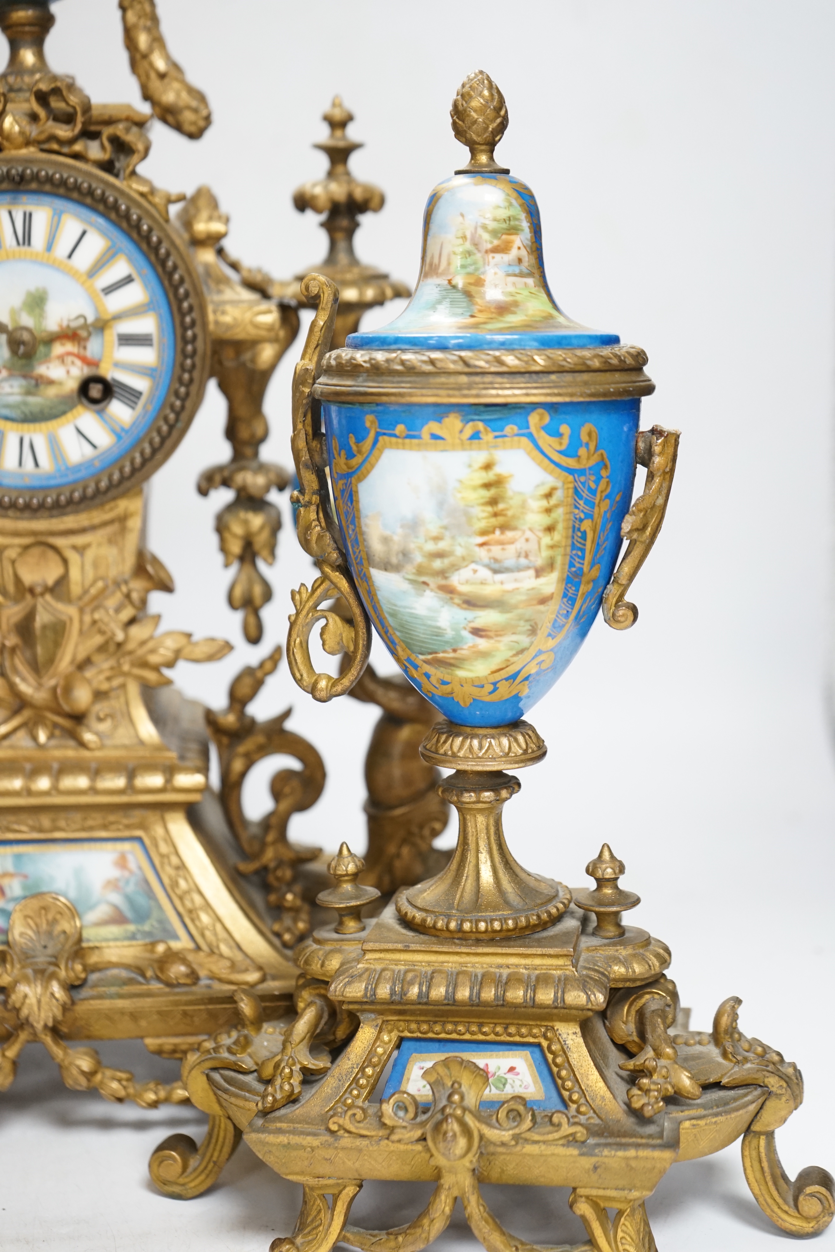 A Sevres style porcelain and gilt metal clock garniture, 44cm high